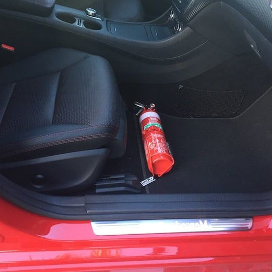 Mercedes-Benz C63 AMG cabin with a red fire extinguisher mounted on a KAP bracket at the base of the front seat