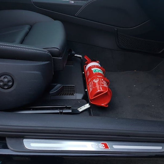 Volkswagen Tiguan cabin with a red fire extinguisher mounted on a KAP bracket at the base of the front seat