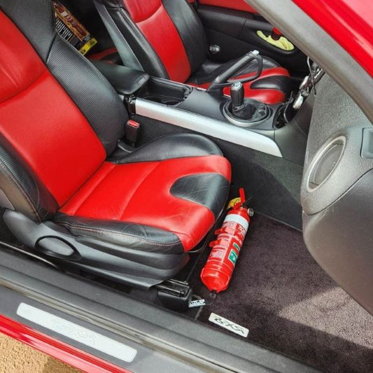 Mazda RX-8 cabin with a red fire extinguisher mounted on a KAP bracket at the base of the left front seat