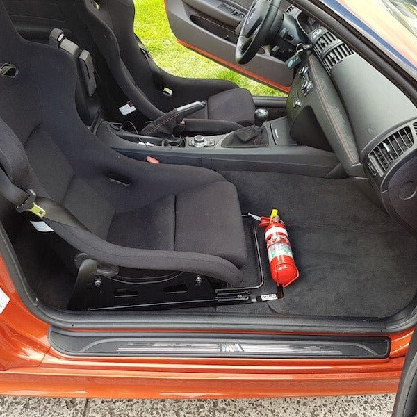 Mini Cooper / JCW cabin with a red fire extinguisher mounted on a KAP bracket at the base of the front seat