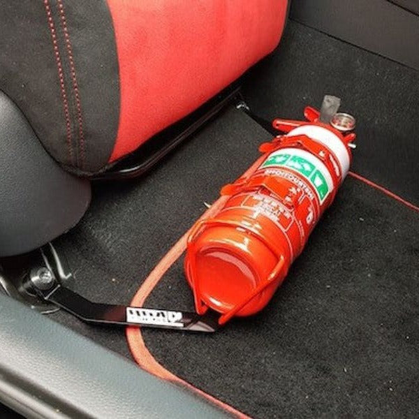 Close-up of a red fire extinguisher held in a KAP bracket at the base of the front seat in a Honda Civic Type R