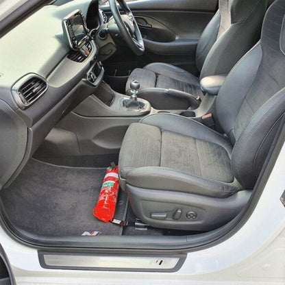 Hyundai i30 N cabin with a red fire extinguisher mounted on a KAP bracket at the base of the front seat