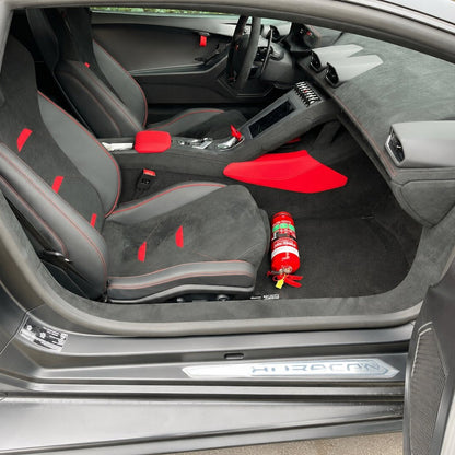 Audi R8 cabin with a red fire extinguisher mounted on a KAP bracket at the base of the front seat