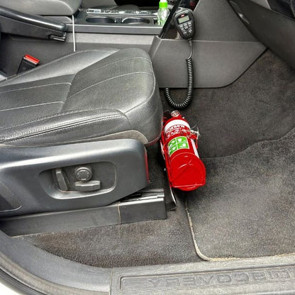 Land Rover Discovery cabin with a red fire extinguisher mounted on a KAP bracket at the base of the front seat