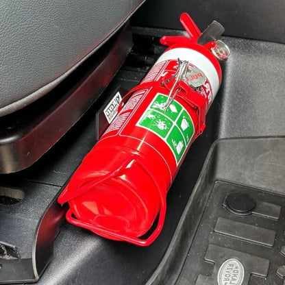 Close-up of a red fire extinguisher held in a KAP bracket at the base of the front seat in a Land Rover Discovery