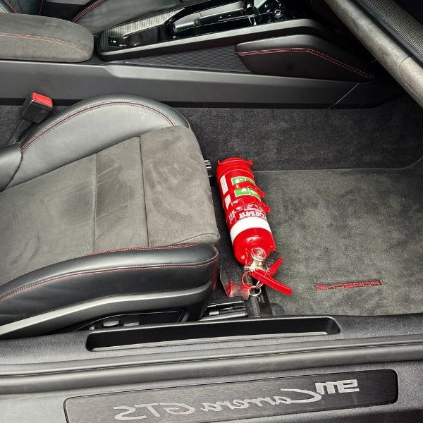 Porsche 718 Boxster cabin with a red fire extinguisher mounted on a KAP bracket at the base of the front seat
