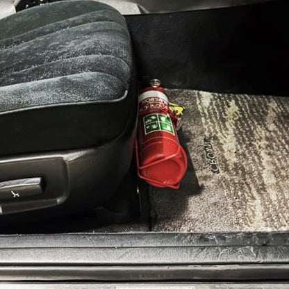Close-up of a red fire extinguisher held in a KAP bracket at the base of the front seat in a Toyota Aristo / Lexus GS