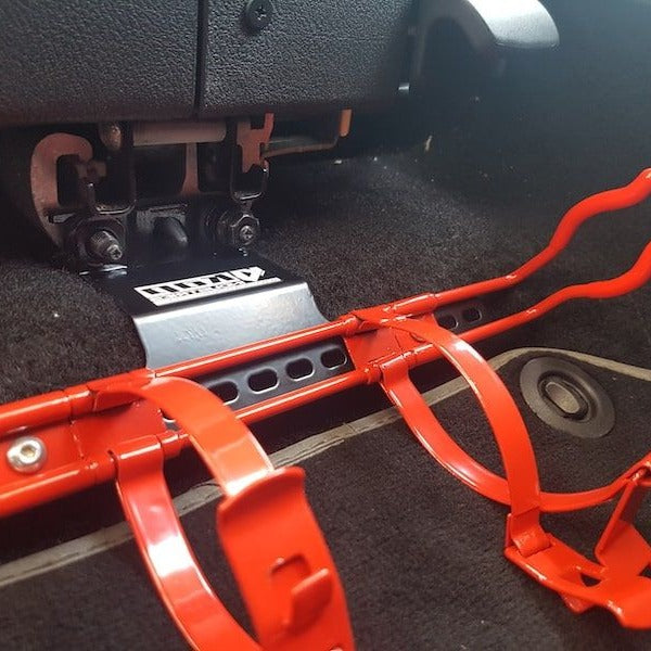 KAP fire extinguisher bracket bolted to the front seat rails of a Volkswagen New Beetle, before the extinguisher is fitted