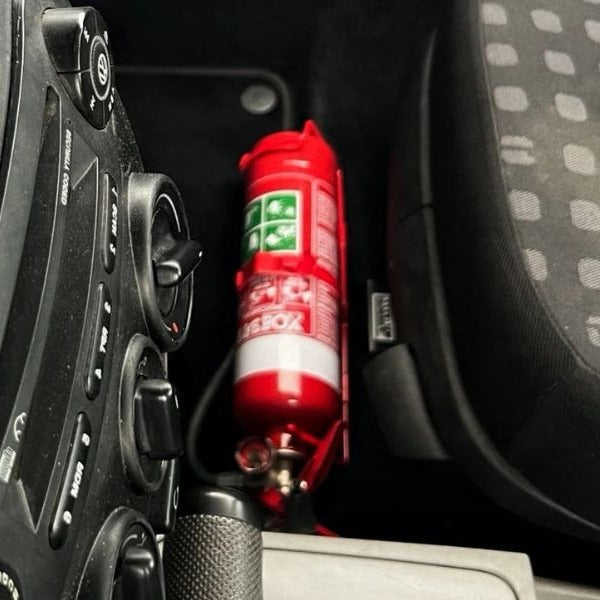 Volkswagen New Beetle footwell with a red fire extinguisher mounted on a KAP bracket at the base of the front seat