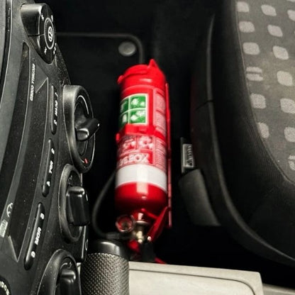 Volkswagen New Beetle footwell with a red fire extinguisher mounted on a KAP bracket at the base of the front seat
