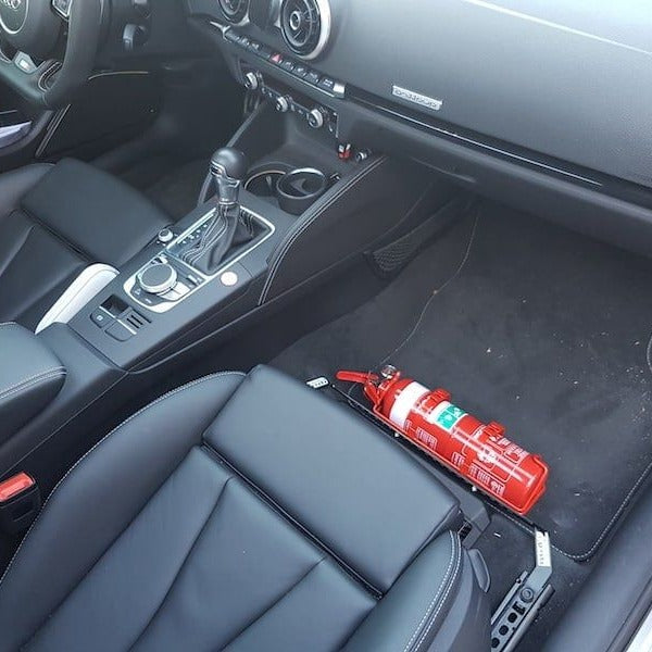 Volkswagen Tiguan cabin with a red fire extinguisher mounted on a KAP bracket at the base of the front seat