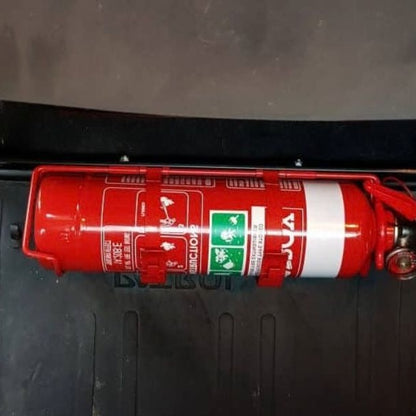 Close-up of a red fire extinguisher held in a KAP bracket at the base of the left front seat in a Nissan Armada