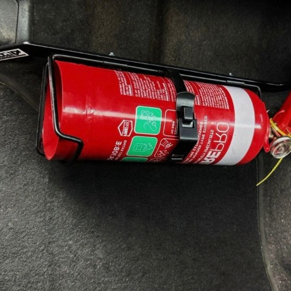 Close-up of a extinguisher held in a KAP bracket at the base of the right front seat in a Toyota LandCruiser 80 Series