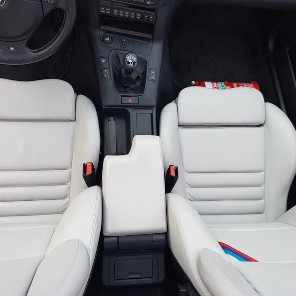 BMW 3 Series cabin with a red fire extinguisher mounted on a KAP bracket at the base of the front seat