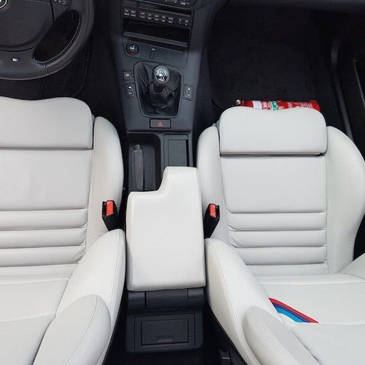 BMW 3 Series cabin with a red fire extinguisher mounted on a KAP bracket at the base of the front seat