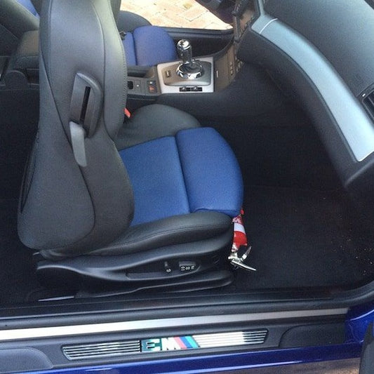 BMW Z4 / Z4 M cabin with a red fire extinguisher mounted on a KAP bracket at the base of the front seat