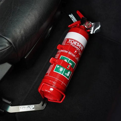 Close-up of a red fire extinguisher held in a KAP bracket at the base of the front seat in a BMW Z4 / Z4 M