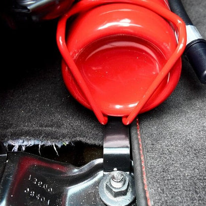 KAP fire extinguisher bracket bolted to the front seat rails of a Chevrolet Corvette, shown before the extinguisher is fitted