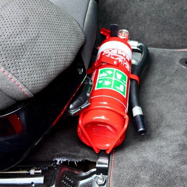 Close-up of a red fire extinguisher held in a KAP bracket at the base of the front seat in a Chevrolet Corvette