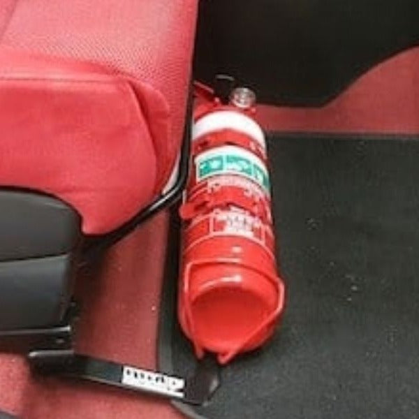 Close-up of a red fire extinguisher held in a KAP bracket at the base of the front seat in a Honda Civic Type R