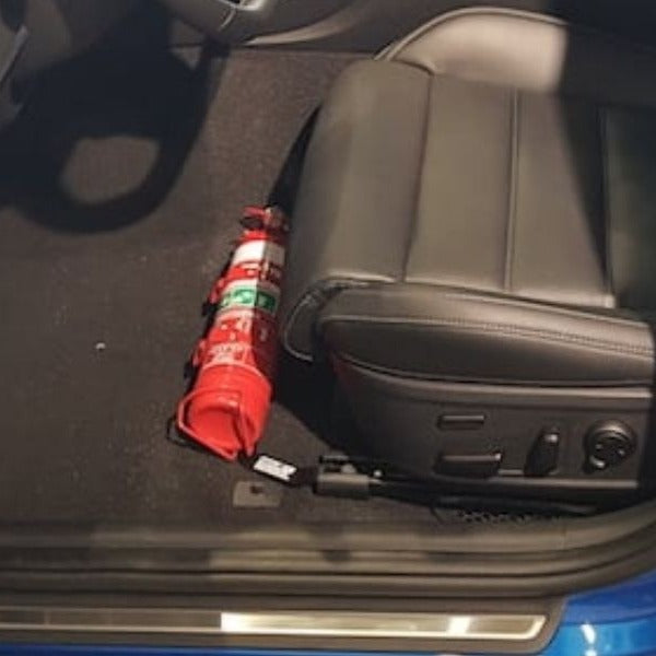 Kia Stinger cabin with a red fire extinguisher mounted on a KAP bracket at the base of the front seat