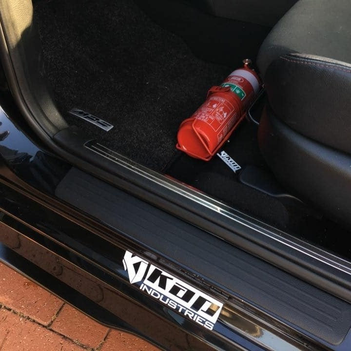 Mazdaspeed3 cabin with a red fire extinguisher mounted on a KAP bracket at the base of the front seat
