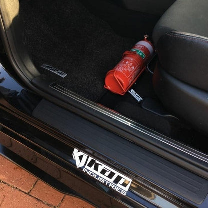 Mazdaspeed3 cabin with a red fire extinguisher mounted on a KAP bracket at the base of the front seat