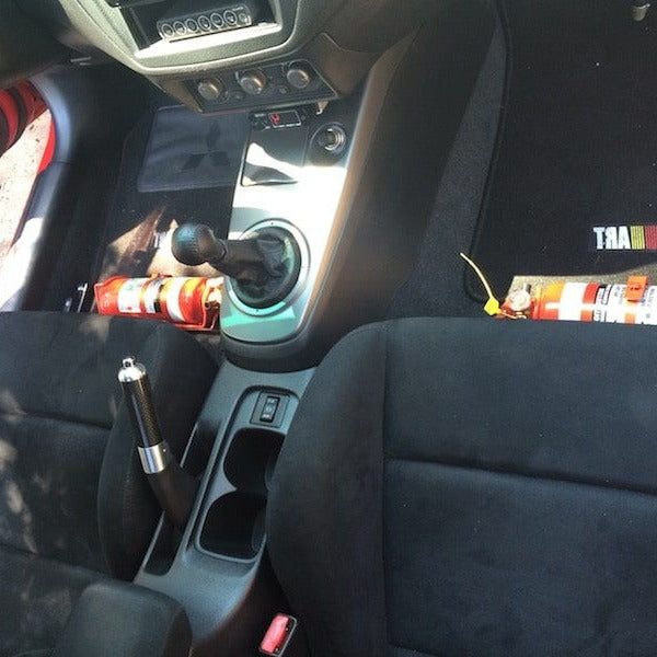 Mitsubishi Evo VIII cabin with a red fire extinguisher mounted on a KAP bracket at the base of the left front seat