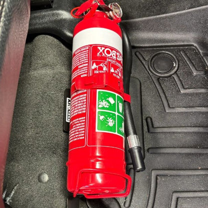 Close-up of a red fire extinguisher held in a KAP bracket at the base of the front seat in a RAM 1500