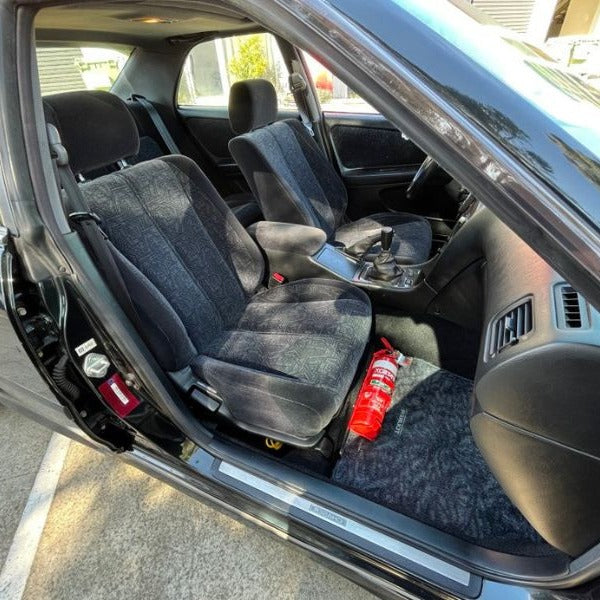 Toyota Chaser/Cresta/Mark II with the door open, showing a red fire extinguisher mounted at the base of the left front seat