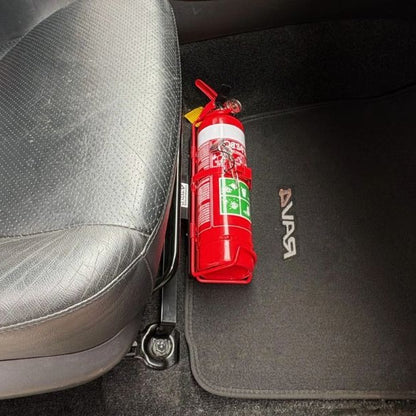 Close-up of a red fire extinguisher held in a KAP bracket at the base of the front seat in a Toyota RAV4