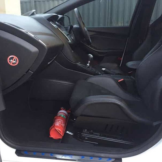 Volvo C30 cabin with a red fire extinguisher mounted on a KAP bracket at the base of the front seat