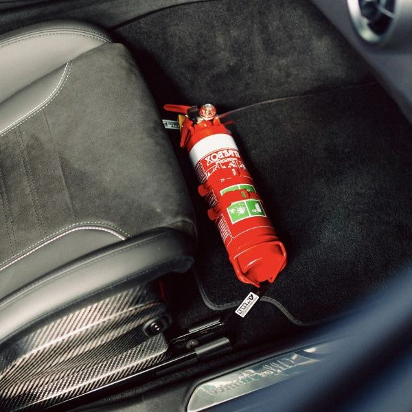 Close-up of a red fire extinguisher held in a KAP bracket at the base of the front seat in a Alfa Romeo Giulia
