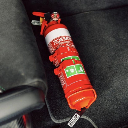 Close-up of a red fire extinguisher held in a KAP bracket at the base of the front seat in a Alfa Romeo Giulia